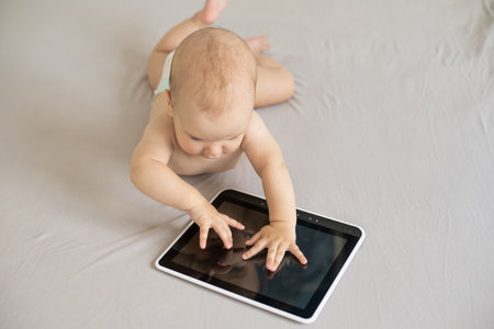 baby boy playing with digital tablet isolated on whiteの写真素材