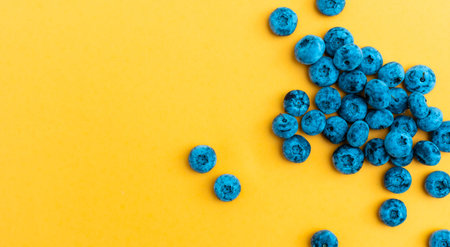 Colorful fruit pattern of blueberries on yellow background. Top view. Flat layの写真素材