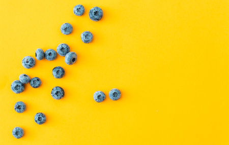 Tasty ripe blueberries on yellow background, flat layの写真素材