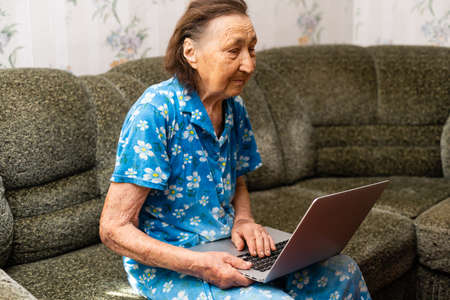 Very elderly woman holding a laptopの写真素材