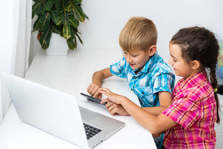 Distance learning online education. A schoolboy boy studies at home and does school homework. A home distance learningの写真素材