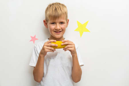 photo shoot of a child eating a corn cob with a white backgroundの写真素材