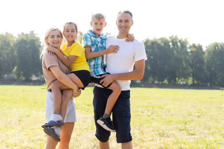 Happy family walking in field and holding hands