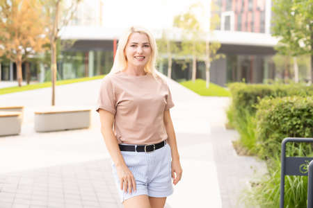 Portrait of young beautiful smiling hipster woman in trendy summer shorts. Sexy carefree model posing on the street backgroundの写真素材