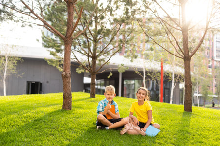 portrait of boy with girl walking to school along with backpack behindの写真素材