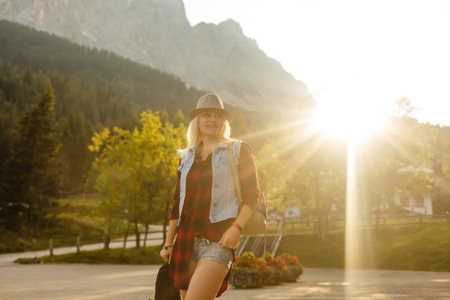 young woman in field, nature background, lighthouse, hipster style, bohemian outfit, denim jacket, black hat, smiling, happy, summer, sunny, stylish accessories, bracelets, handsの写真素材