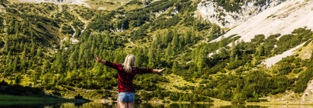Hiker woman standing with hands up achieving the top. Girl welcomes a sun. Conceptual design....