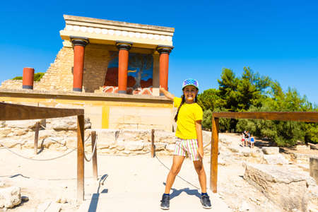 A little girl stops to take a photo of artwork on the walls of the Minoan palace at Knossos. Crete, Greeceの写真素材