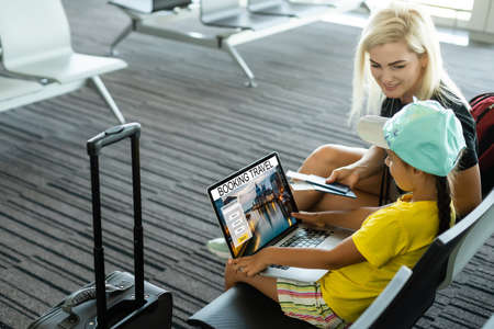 happy mother and daughter at airport travelling togetherの写真素材