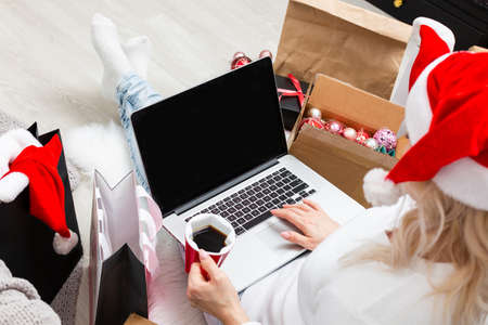 Young woman ordering Christmas gifts online Christmastime decorationsの写真素材