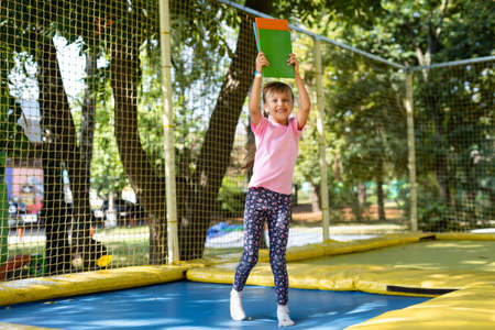 Little child enjoys jumping on trampoline - outside in backyardの写真素材