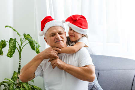 Happy childhood. Child enjoy christmas with Santa claus. Granddaughter spend time with grandpa. Christmas eve. Family.の写真素材