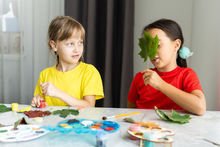 Child painting autumn leaves at homeの写真素材