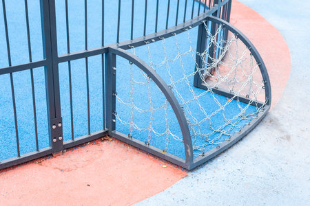Sports arena behind the fences. Selective focus on rusty fences in front