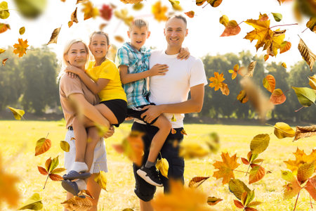 happy beautiful family of five on a walk in the autumn against the background of yellow leaves