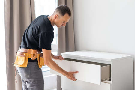 Young male worker repairing furnitureの写真素材