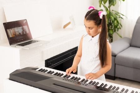 beautiful girl sings while playing on an electronic pianoの写真素材