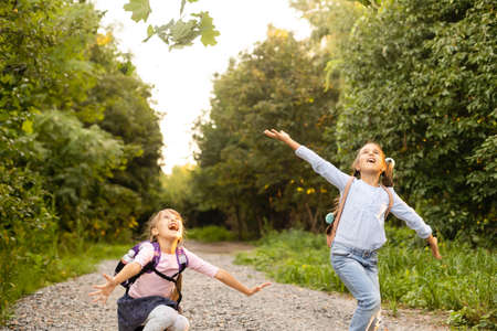 Two cute smiling 8 years old girls posing together in a park on a sunny autumn day. Friendship concept.の写真素材