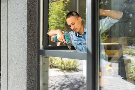Male worker installing window in flat, closeupの写真素材