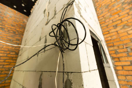 repair of wiring in the building. Electrical wires, wiring, socket on a building wall, home repair. cables.の写真素材