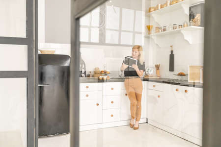 Young woman shopping fresh food online using a digital tablet at home. Concept of buying online using tabletの写真素材