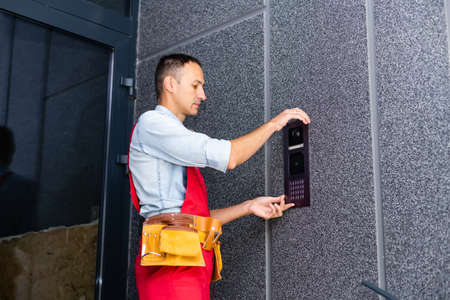 Builder installing an intercom. renovation in a renovated buildingの写真素材