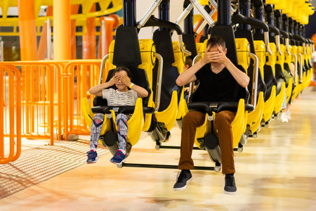 Smiling family riding on a rollercoaster at an amusement park.の写真素材