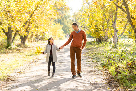Happy father with daughter in fall seasonの写真素材
