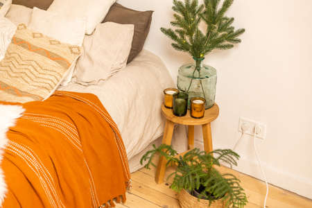 Christmas tree branches near the bed .Christmas interior. Christmas concept. Pillows, pine cones, gypsophila and fir tree branchの写真素材