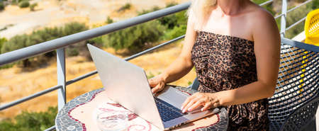 woman in hotel room with notebook and ocean viewの写真素材