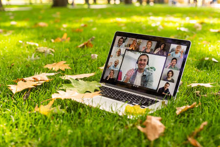 Image of autumn park and videocall by laptop computerの写真素材