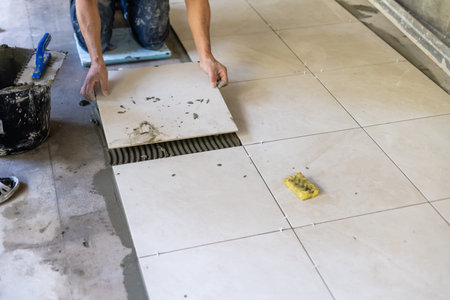 Builder puts the tiles on the floor, the repair