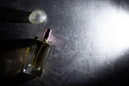 Beautiful composition with bottle of perfume on dark background, flat layの写真素材