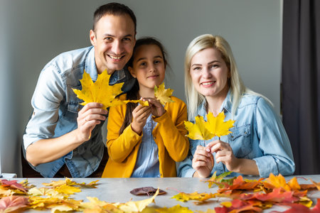 family At Home Doing Craft And Making Picture From Leaves In Kitchenの写真素材