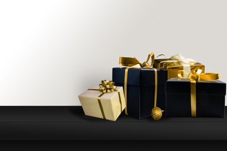Black gifts with gold ribbons. Christmas gift boxes on black background. Merry Christmas and Happy...