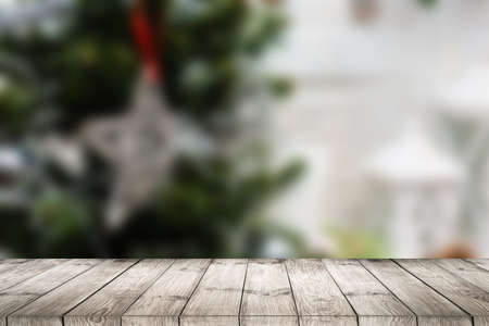 wooden Table and blur background, Christmas background with Christmas tree and gift.の写真素材