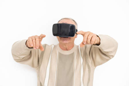 technology, augmented reality, gaming, entertainment and people concept - senior man with virtual headset or 3d glasses playing videogame at home.の写真素材