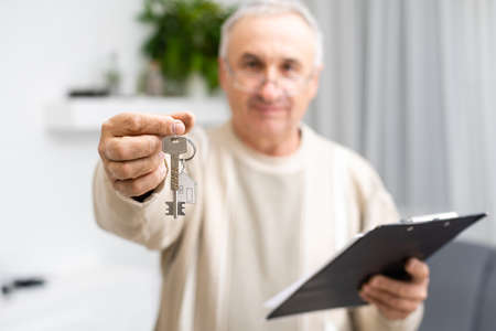 elderly man with documents for an apartment in his living room.の写真素材