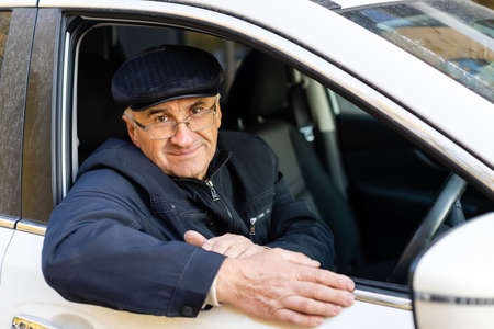 Smiling happy elderly man in the new carの写真素材