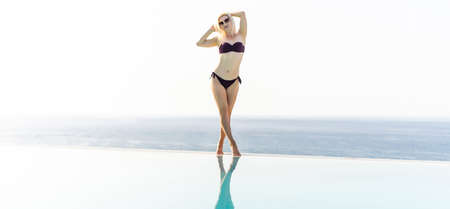 Young sexy blonde woman posing near the pool. Young pretty womanの写真素材