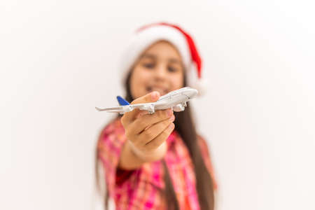 Girl in Santa hat holding model airplaneの写真素材