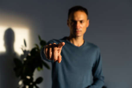 Young handsome man wearing casual t-shirt presenting with hand and pointing with finger.の写真素材