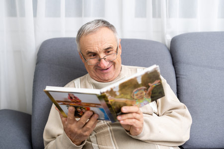 An old man in a hospital ward watching photobook