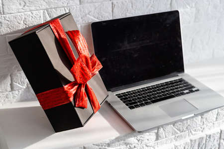 Christmas online shopping. Laptop with copy space on screen lay on white, present boxes. Internet commerce on winter holidays conceptの写真素材