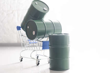 Small shopping cart and barrels isolated on dark backgroundの写真素材