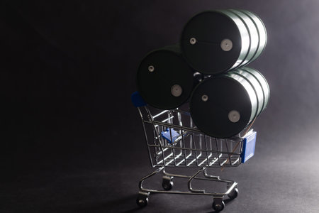 Small shopping cart and barrels isolated on dark background