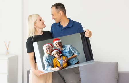 family holding photo canvas with christmas pictureの写真素材