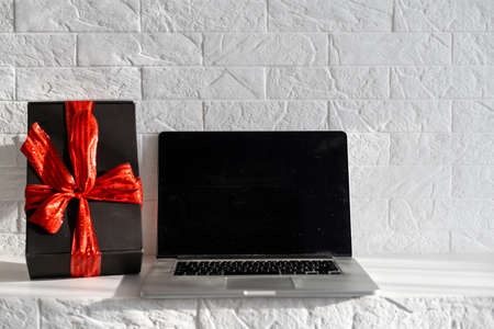 Christmas online shopping. Laptop with copy space on screen lay on white, present boxes. Internet commerce on winter holidays conceptの写真素材