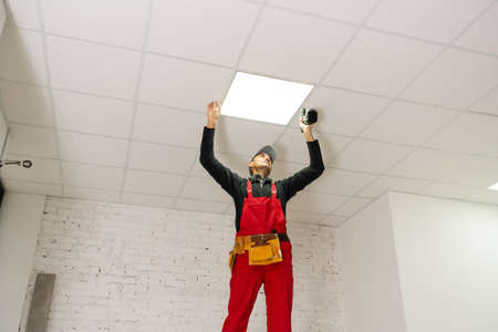 a builder replacing ceiling panel, working, armstrong.の写真素材