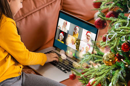 Attractive happy young girl student having video chat, waving. christmasの写真素材